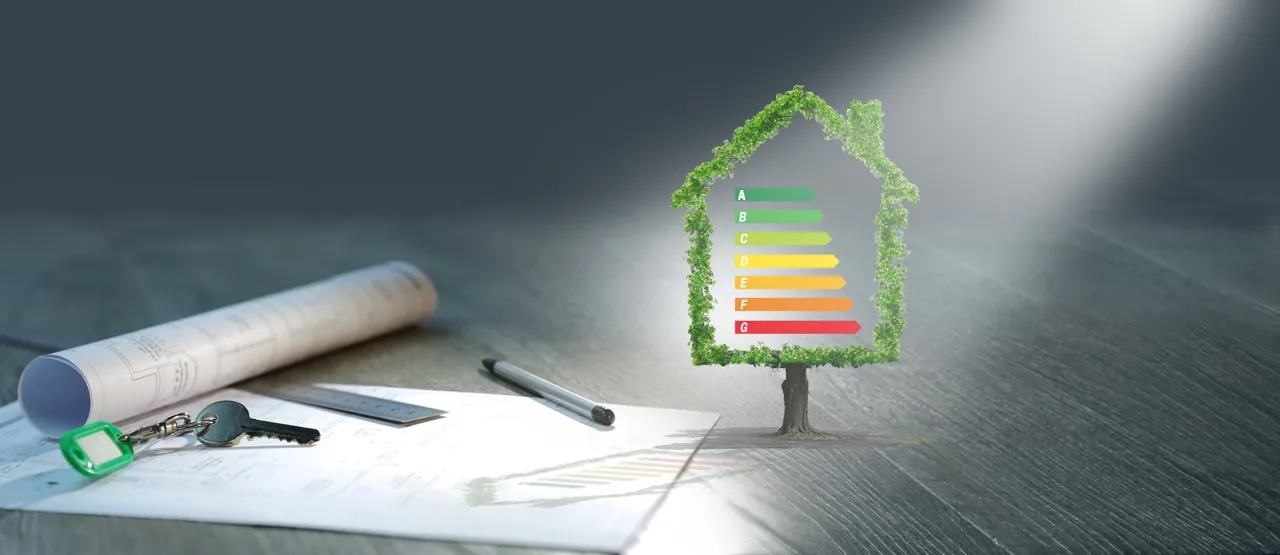 Haus mit Energieeffizienzskala von A bis G, daneben Baupläne, Schlüssel und Stift.